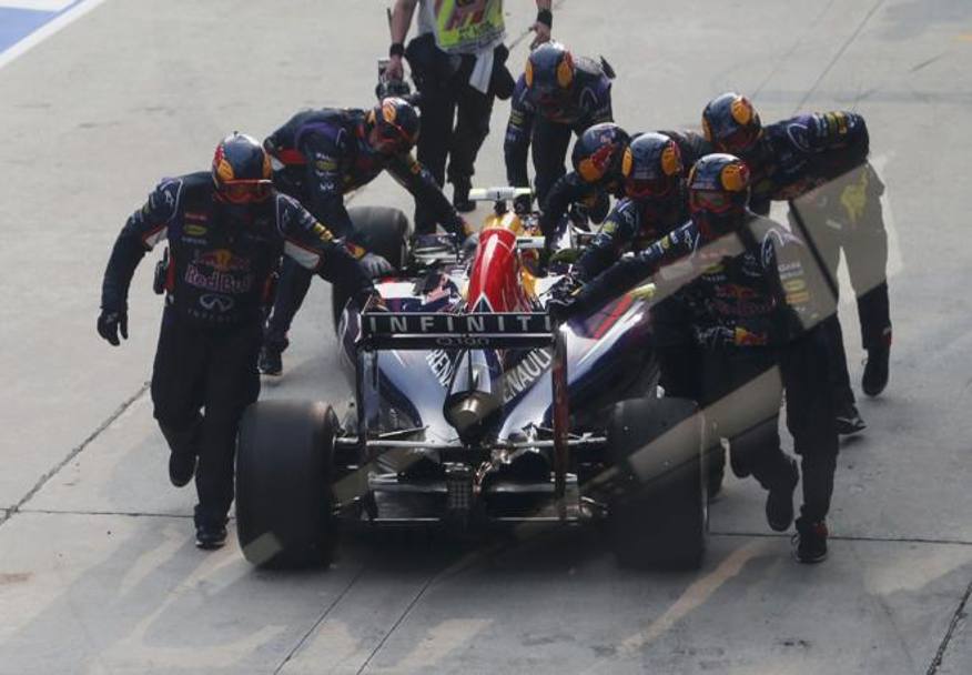 Ricciardo spinto indietro dai meccanici Red Bull nella pit lane: l&#39;australiano ha subito sia il cedimento dell&#39;ala anteriore, sia l&#39;errato fissaggio della ruota anteriore sinistra dopo un pit stop: immediata è scattata pure una penalità. Reuters
